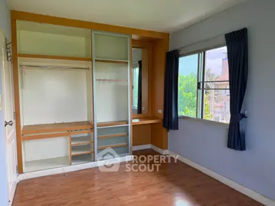 Spacious bedroom with built-in closet and large windows offering natural light and scenic views.