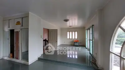 Spacious living room with large windows and glossy tile flooring