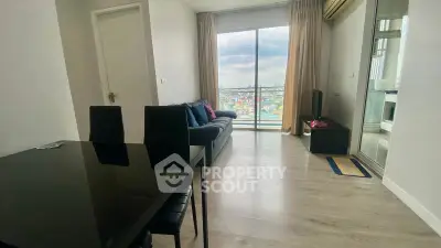 Modern living room with large window offering stunning city view, sleek furniture, and elegant decor.