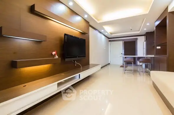 Modern living room with sleek design and open layout, featuring a wall-mounted TV and stylish lighting.