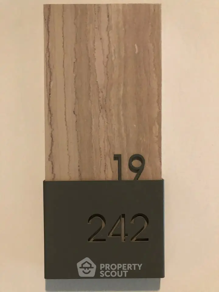 Modern apartment number plaque with stylish design and neutral tones.