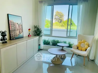 Bright modern living room with stylish furniture and large window view.