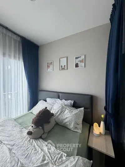 Cozy bedroom with stylish decor and large window, perfect for relaxation and comfort.