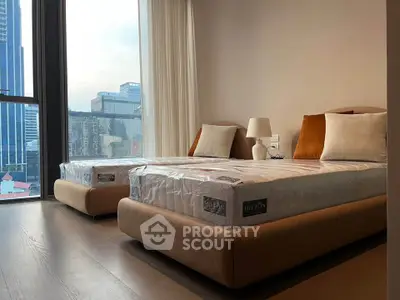 Modern bedroom with twin beds and city view, perfect for urban living.
