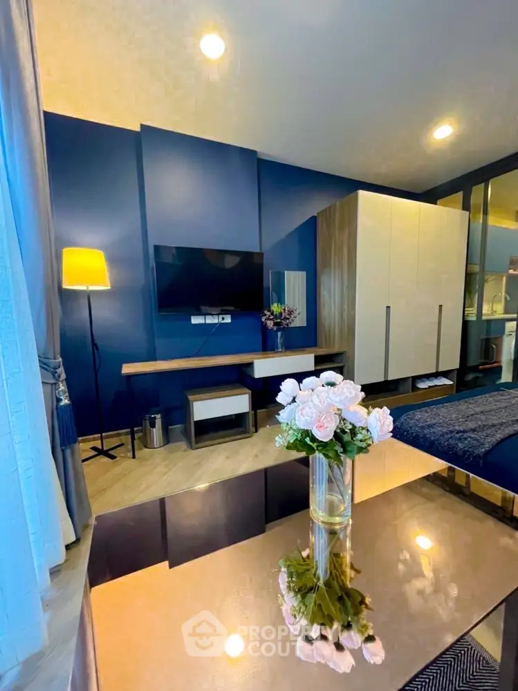 Modern living room with stylish decor and elegant furniture, featuring a wall-mounted TV and a cozy ambiance.