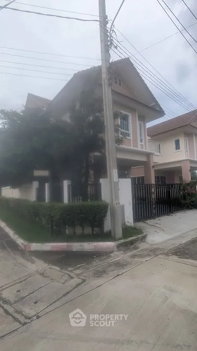 Charming two-story house with lush greenery and modern design in a serene neighborhood.