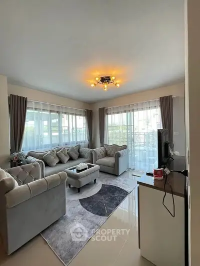 Elegant living room with plush sofas and modern lighting in a bright, airy space.