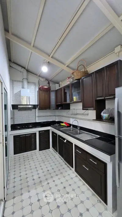 Spacious kitchen with modern dark wood cabinets and sleek countertops
