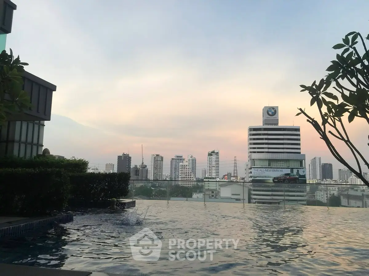 Stunning cityscape view from a luxurious rooftop infinity pool at sunset.