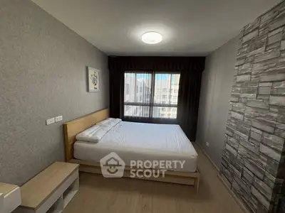 Modern bedroom with stylish decor and large window offering natural light.