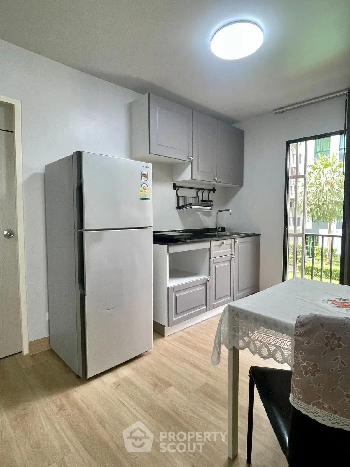 Modern kitchen with sleek cabinets and large fridge in a bright apartment