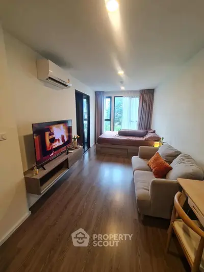 Modern studio apartment with cozy living area and large windows