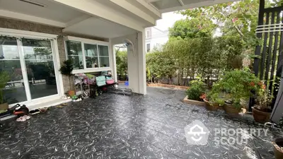 Spacious garden patio with tiled flooring and lush greenery