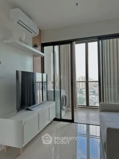 Modern living room with city view, sleek furniture, and large TV in a high-rise apartment.