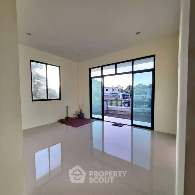 Spacious empty room with large windows and glossy floor, perfect for customization.