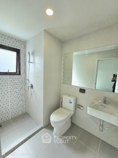 Modern bathroom with sleek shower and large mirror in contemporary home