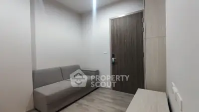 Modern minimalist living room with gray sofa and wooden door