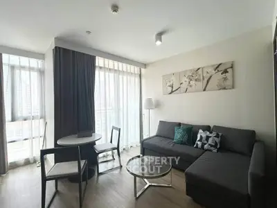 Modern living room with stylish decor and natural light in a high-rise apartment.