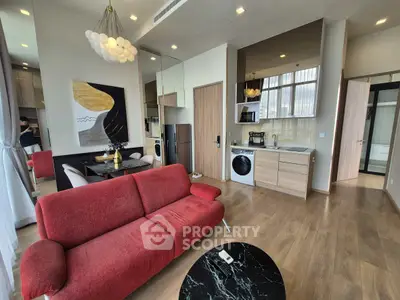 Modern open-plan living room with red sofa and stylish kitchen