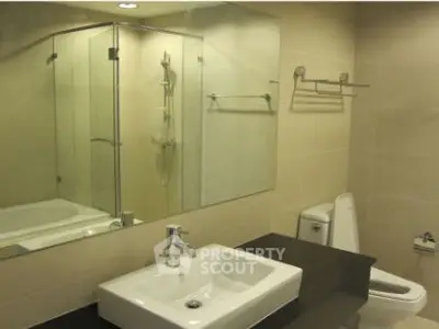 Modern bathroom with glass shower and sleek fixtures in a contemporary home.