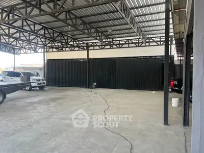 Spacious industrial warehouse with high ceilings and ample parking space.