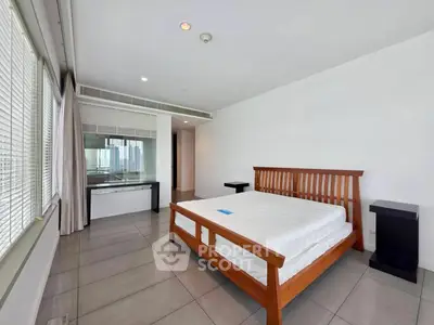 Spacious modern bedroom with large windows and wooden bed frame