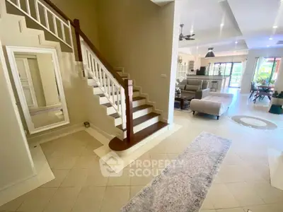 Spacious open-plan living room with elegant staircase and modern decor