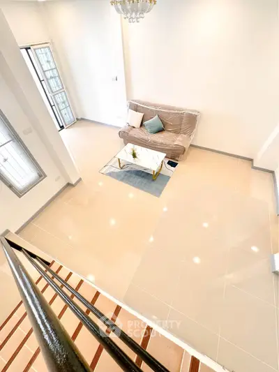 Spacious living room with modern decor and elegant staircase in a bright, airy home.