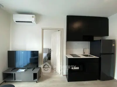 Modern compact apartment with sleek kitchen and cozy living area, featuring air conditioning and stylish decor.