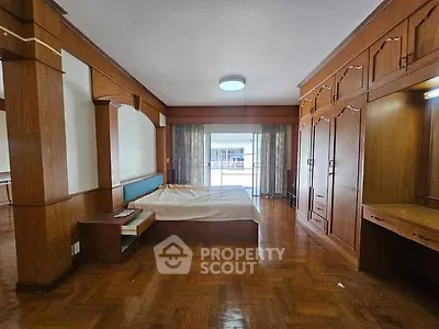 Spacious bedroom with wooden flooring and built-in wardrobe