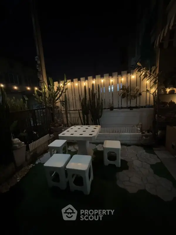 Charming outdoor patio with ambient lighting and modern seating, perfect for evening relaxation.