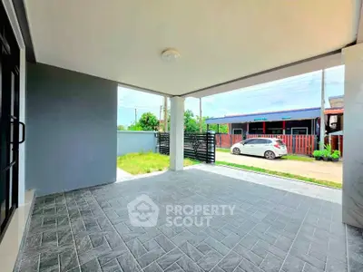Spacious covered patio with tiled flooring and garden view, perfect for outdoor relaxation.
