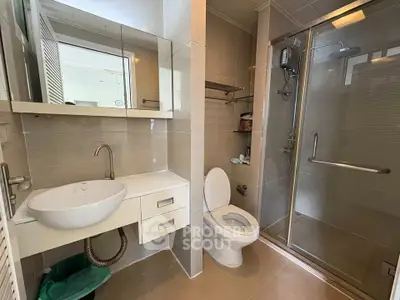Modern bathroom with glass shower and sleek fixtures in a contemporary home.
