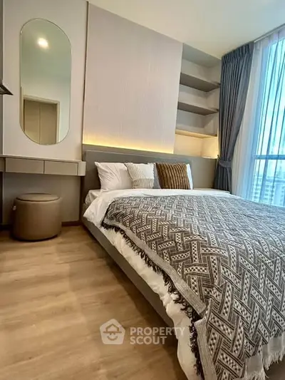 Modern bedroom with stylish decor, large window, and cozy bedding in a high-rise apartment.