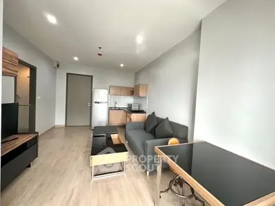 Modern living room with sleek furniture and open kitchen layout in a stylish apartment.