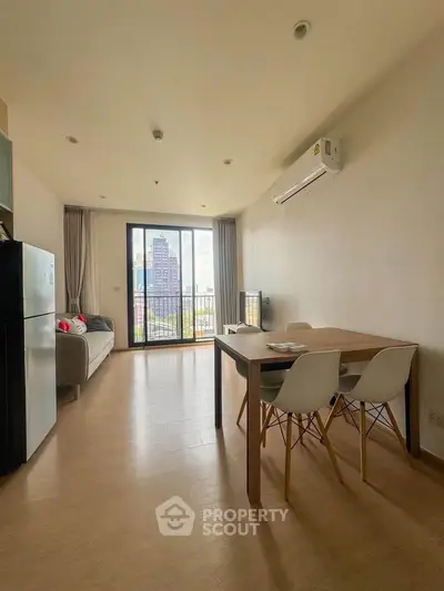 Modern living room with balcony view, featuring minimalist furniture and natural light.