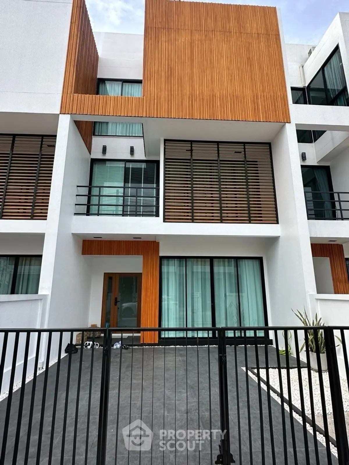 Modern architectural townhouse with sleek wooden accents and spacious balcony.