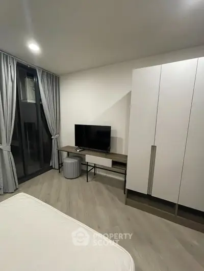 Modern bedroom with sleek furniture and large window for natural light