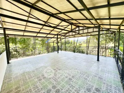 Spacious covered balcony with scenic views and elegant railing design.