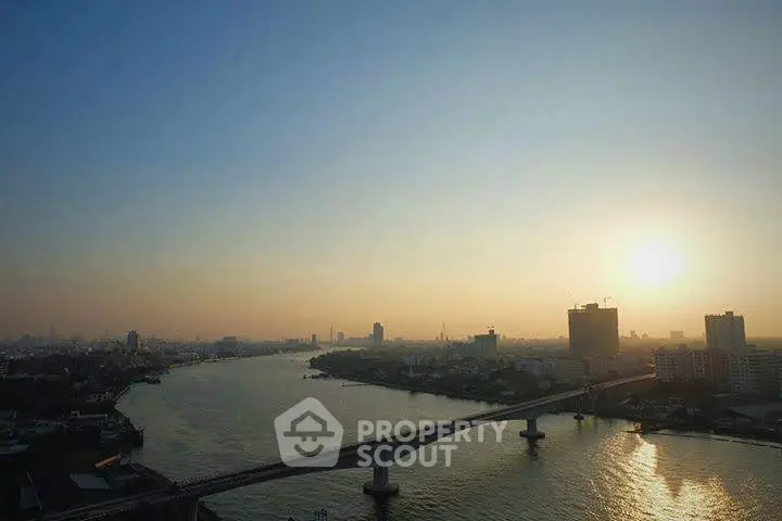 Stunning cityscape view with river and bridge at sunset, perfect for high-rise living.
