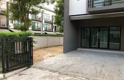 Modern townhouse exterior with private driveway and lush greenery