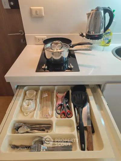 Modern kitchen with sleek appliances and organized drawer in stylish apartment