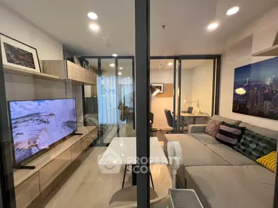 Modern living room with glass partition, cozy seating, and stylish decor in a contemporary apartment.