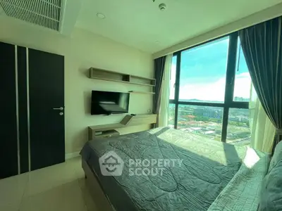 Modern bedroom with large window offering stunning city view and natural light.