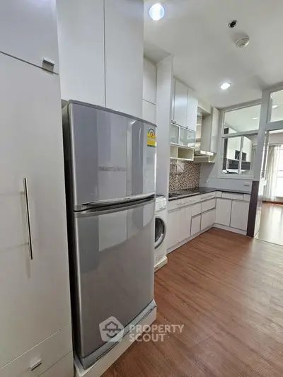 Modern kitchen with sleek appliances and wooden flooring