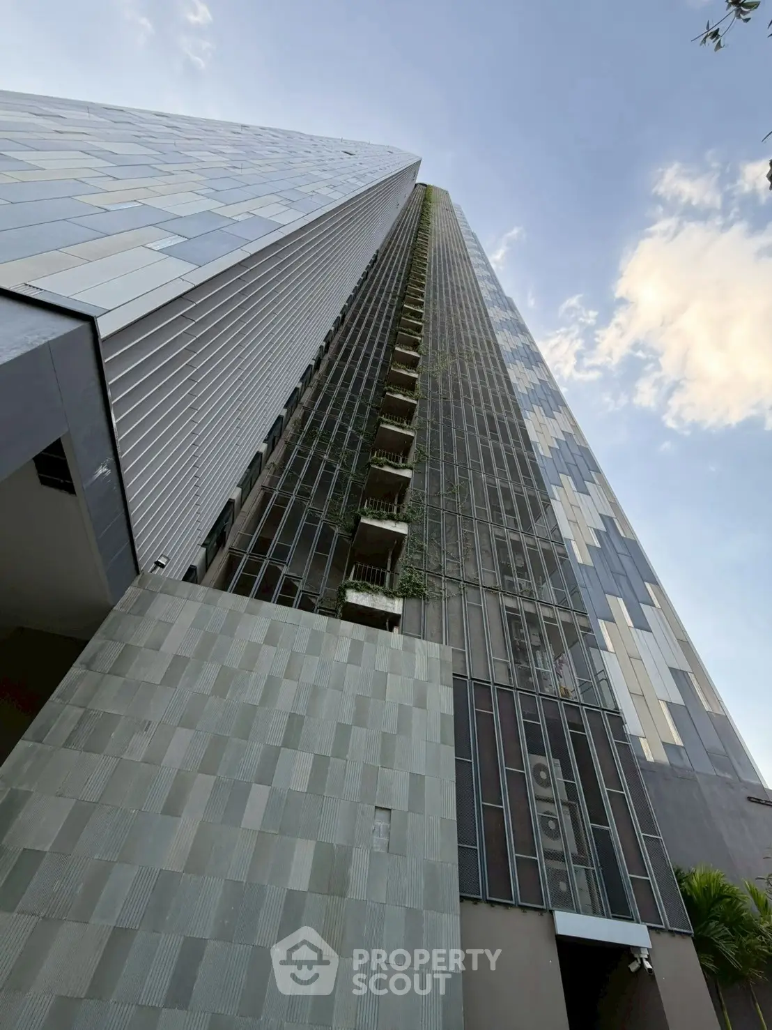Stunning modern high-rise building with sleek architectural design and lush vertical garden.