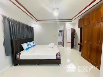 Spacious bedroom with elegant furnishings and ample storage space