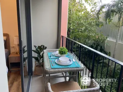 Charming balcony with outdoor dining set and lush garden view