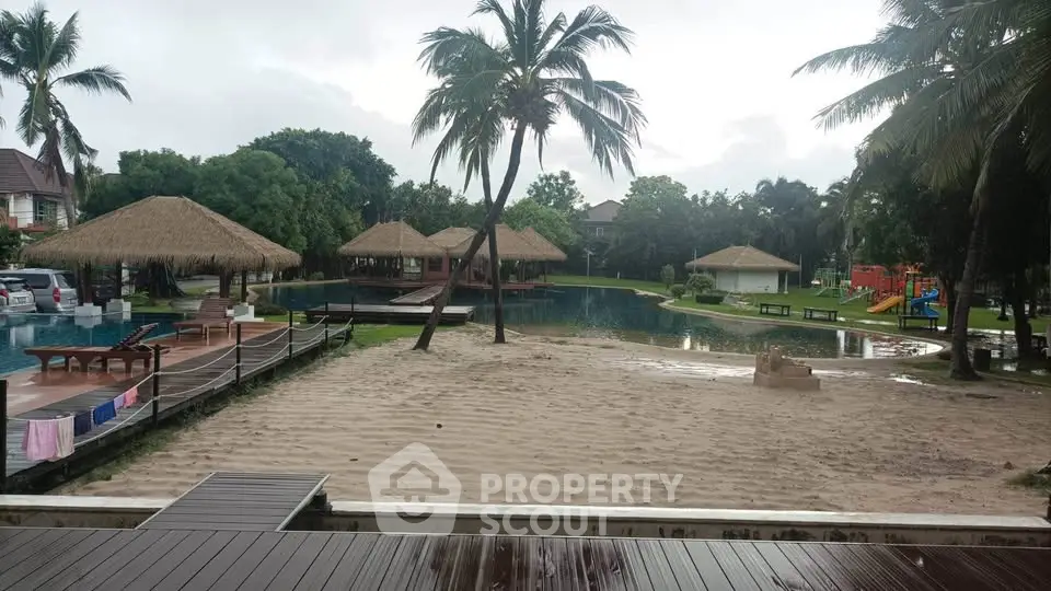 Tropical resort with pool, palm trees, and thatched-roof cabanas for a serene getaway.