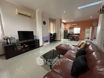 Spacious living room with leather sofa and modern entertainment setup